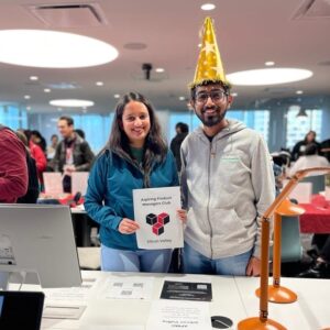 Kaustubha, wearing a novelty party hat, and another student from the Aspiring Product Managers Club at an on-campus event