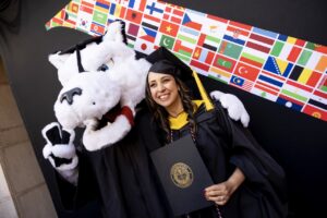 Mascot Paws poses for a photo with a graduate