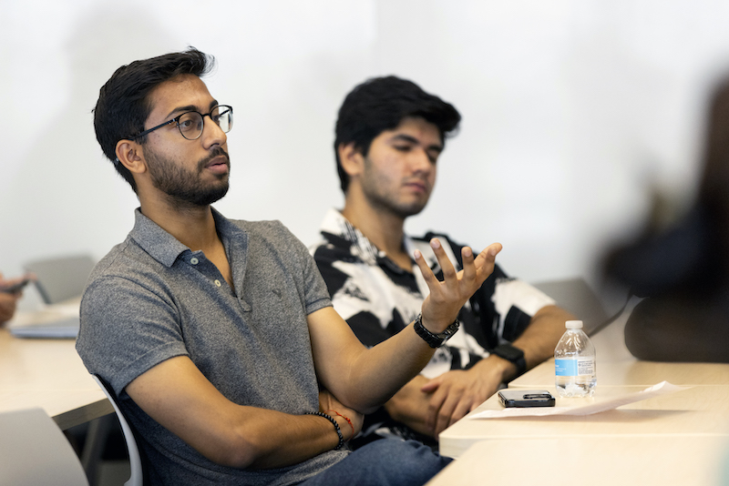 A student is speaking from the audience to ask a question with his hand raised