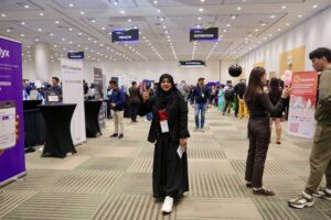 Aisha poses on the floor amongst the booths.