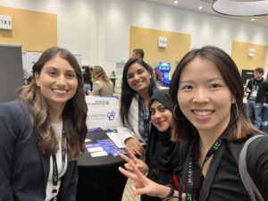 Yi, Aisha, and Northeastern alumna Preeti Jain smile for a photograph with a team member from one of the startups in the Startup Battlefield competition.