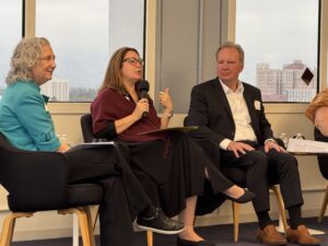 Dr. Mary Murphy speaking during the panel discussion, seated between Caroline Simard and Dave Cortese