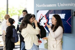 Several people talk and laugh at a mixer event on campus