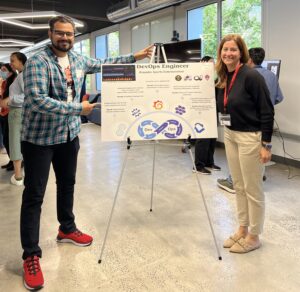 Sahil stands on the left side of the frame, and Erica stands on the right. In between them is a poster from Sahil that explains the functions of the role he completed as a co-op DevOps Engineer in Denver