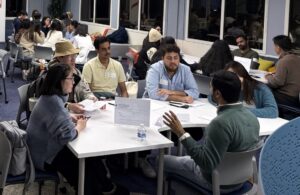 A view of a table at the speed mentoring event where students listen as a visitor speaks