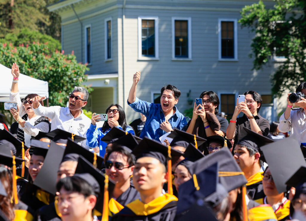 Audience members cheer on their feet during the ceremony