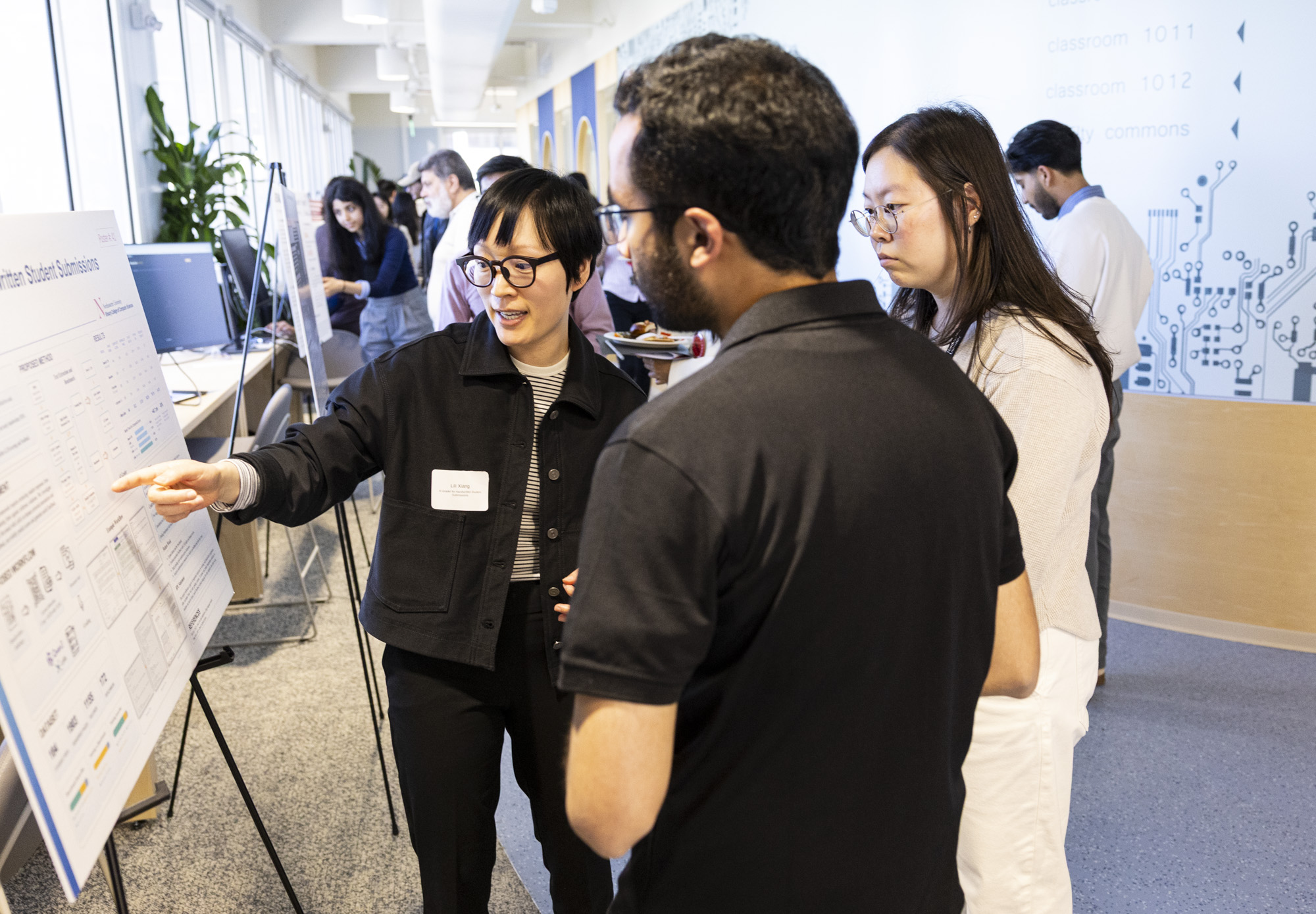 A student gestures to her poster while speaking at the research showcase